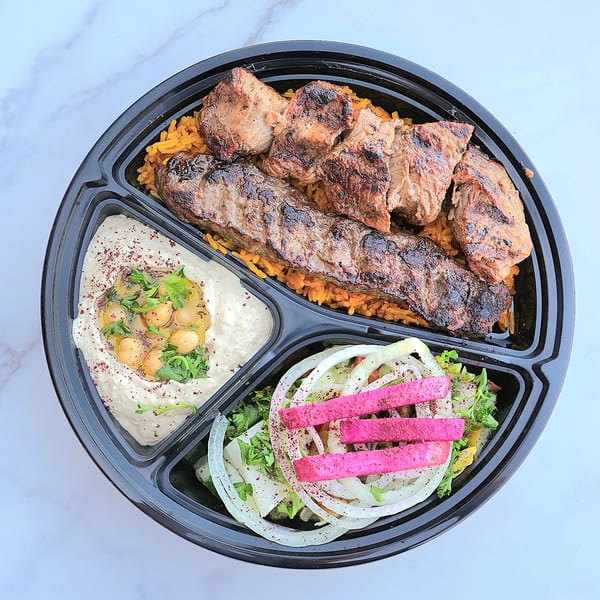 A Don Kabob platter with grilled meats, rice, hummus, and a salad with pickled turnips.